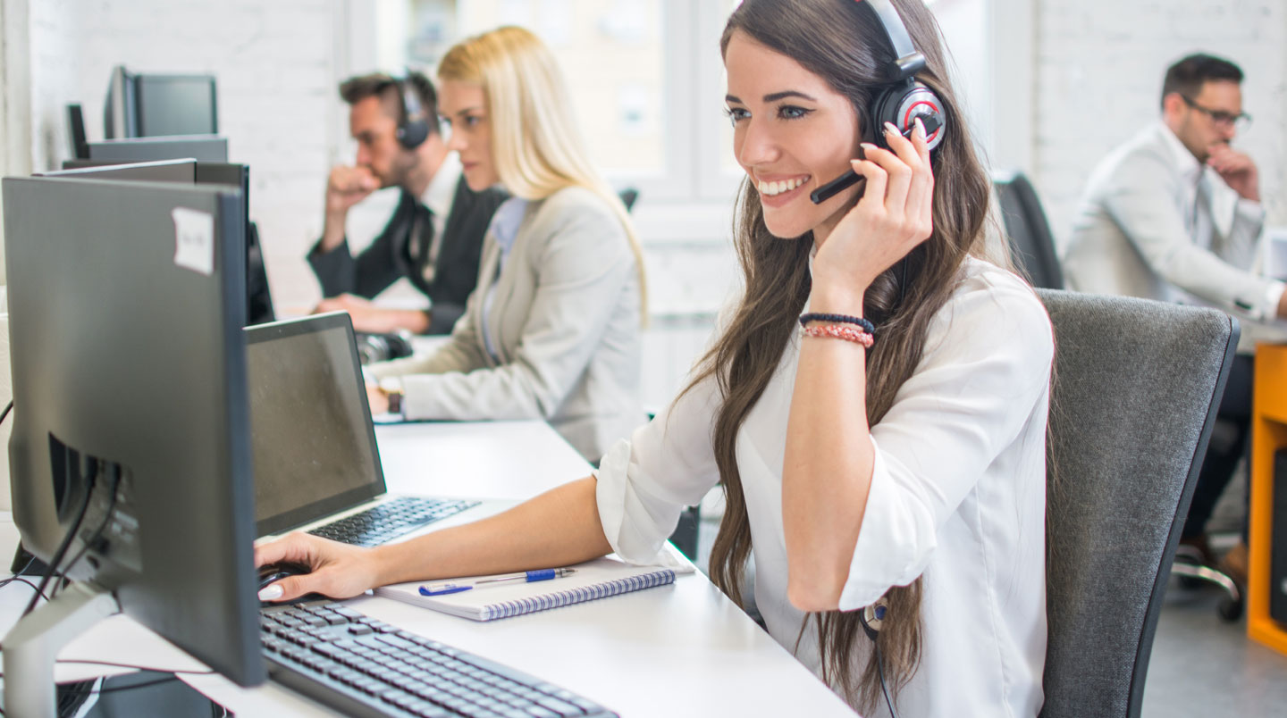 Technicien support IT en open space cherchant la cause d'un incident Microsoft Teams sur son poste de travail, écrans montrant des métriques réseau